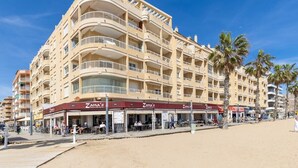 A multi-story hotel with balconies, outdoor seating, and palm trees. - Feel at Home by Fidalsa (La Mata)
