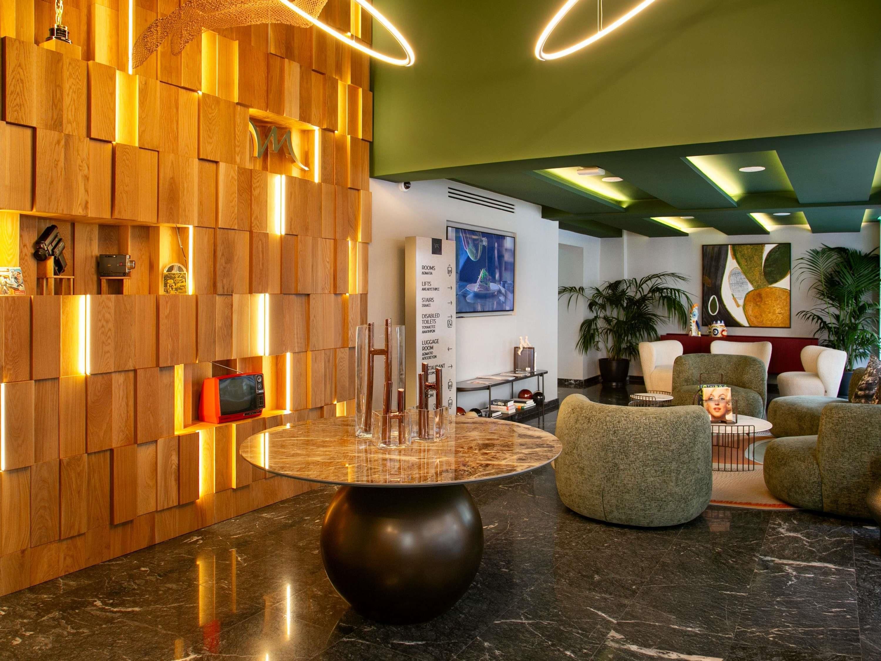 A modern lobby with a wooden wall, a marble table, and comfortable seating.