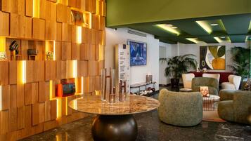 A modern lobby with a wooden wall, a marble table, and comfortable seating.