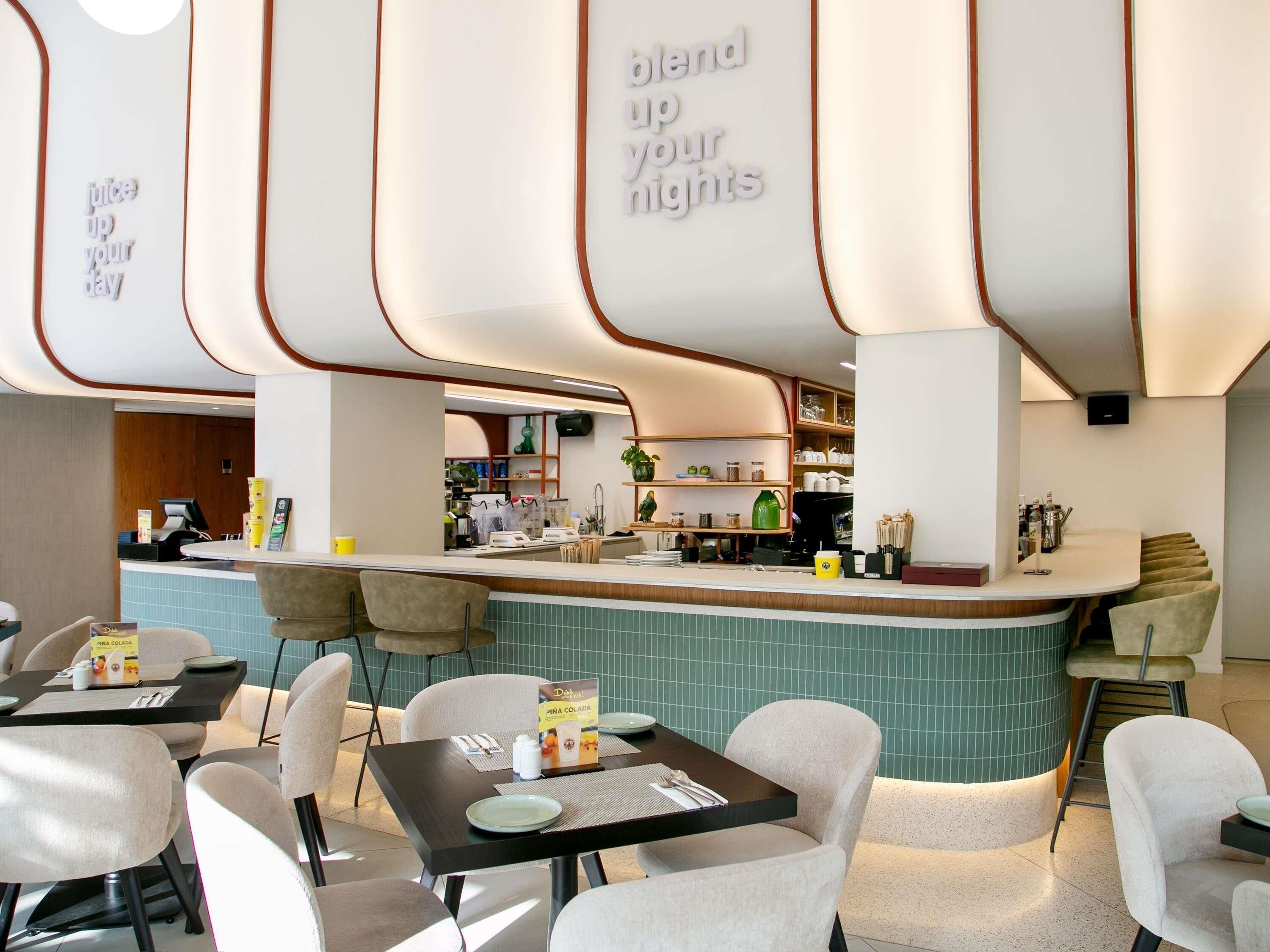 Un espace bar moderne, doté de sièges et d’un comptoir.