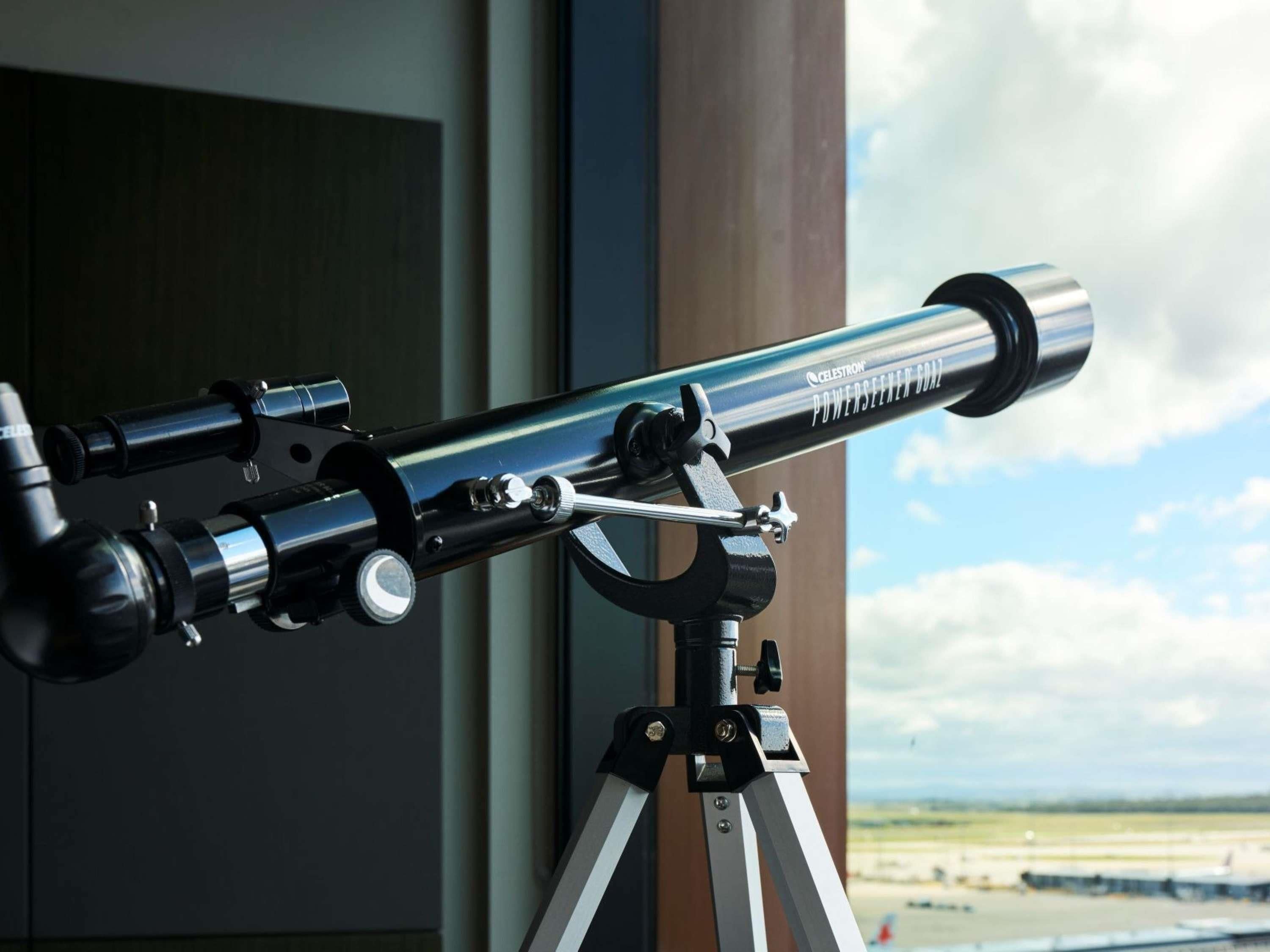 A telescope mounted on a tripod with a clear view of the sky.