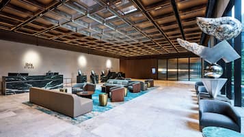 Eine moderne Lobby mit Empfangstresen, einer Sitzecke und einem großen Fenster mit Blick.