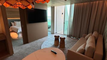 Ein modernes Wohnzimmer mit einem Marmortisch, einem beige farbenen Sofa und besonderen Holz-Pendelleuchten.
