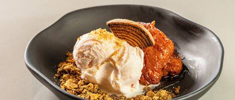 Un dessert con gelato, caramello e un biscotto.