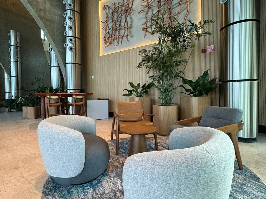 A modern lobby with a curved seating area, a large abstract art piece, and a vertical metallic sculpture.