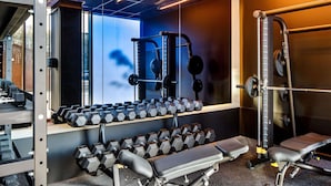 A gym with weight racks, dumbbells, benches, and exercise equipment. - TRIBE Manchester Airport (Manchester)