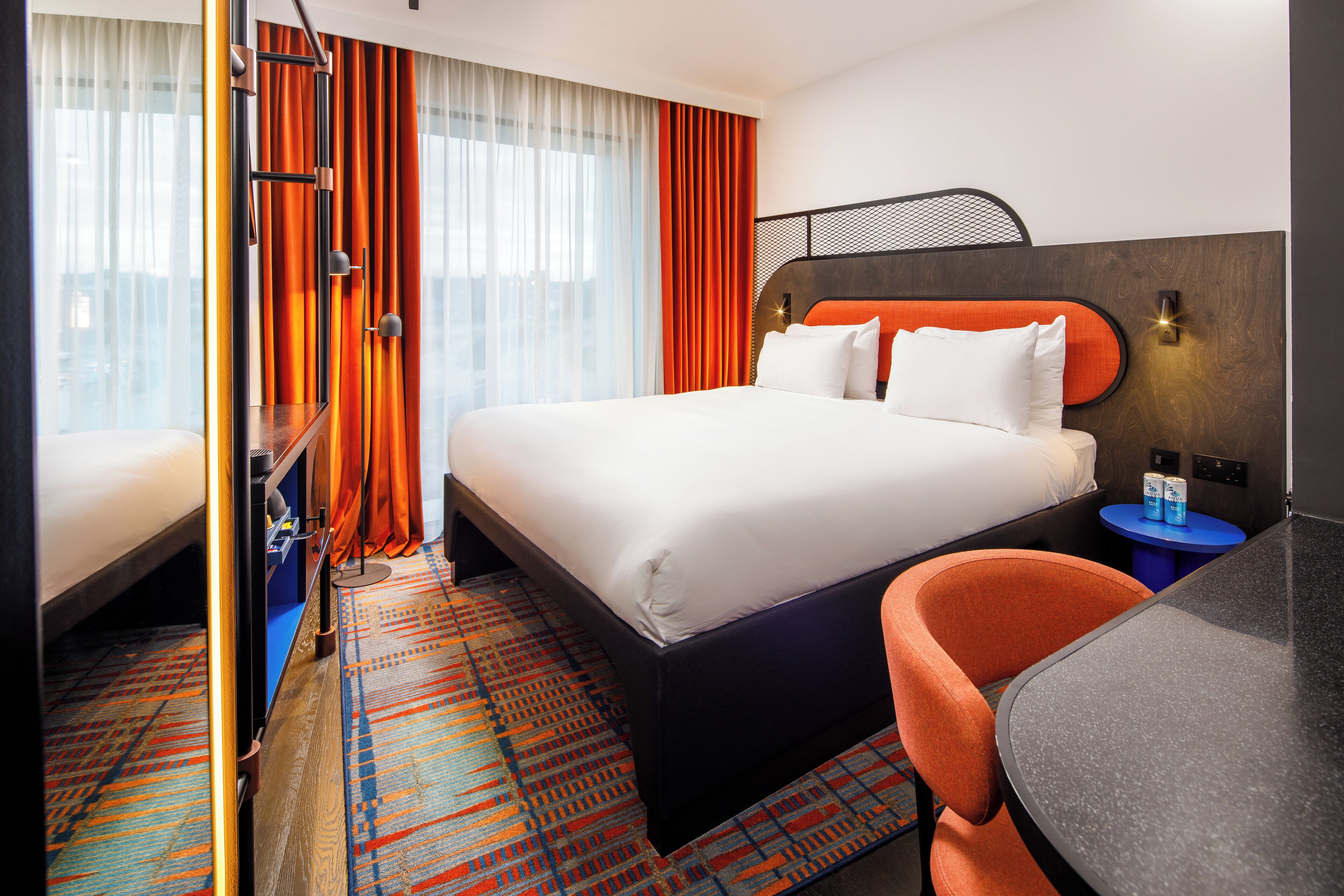 Una habitación de hotel con una cama grande, un escritorio y una silla.