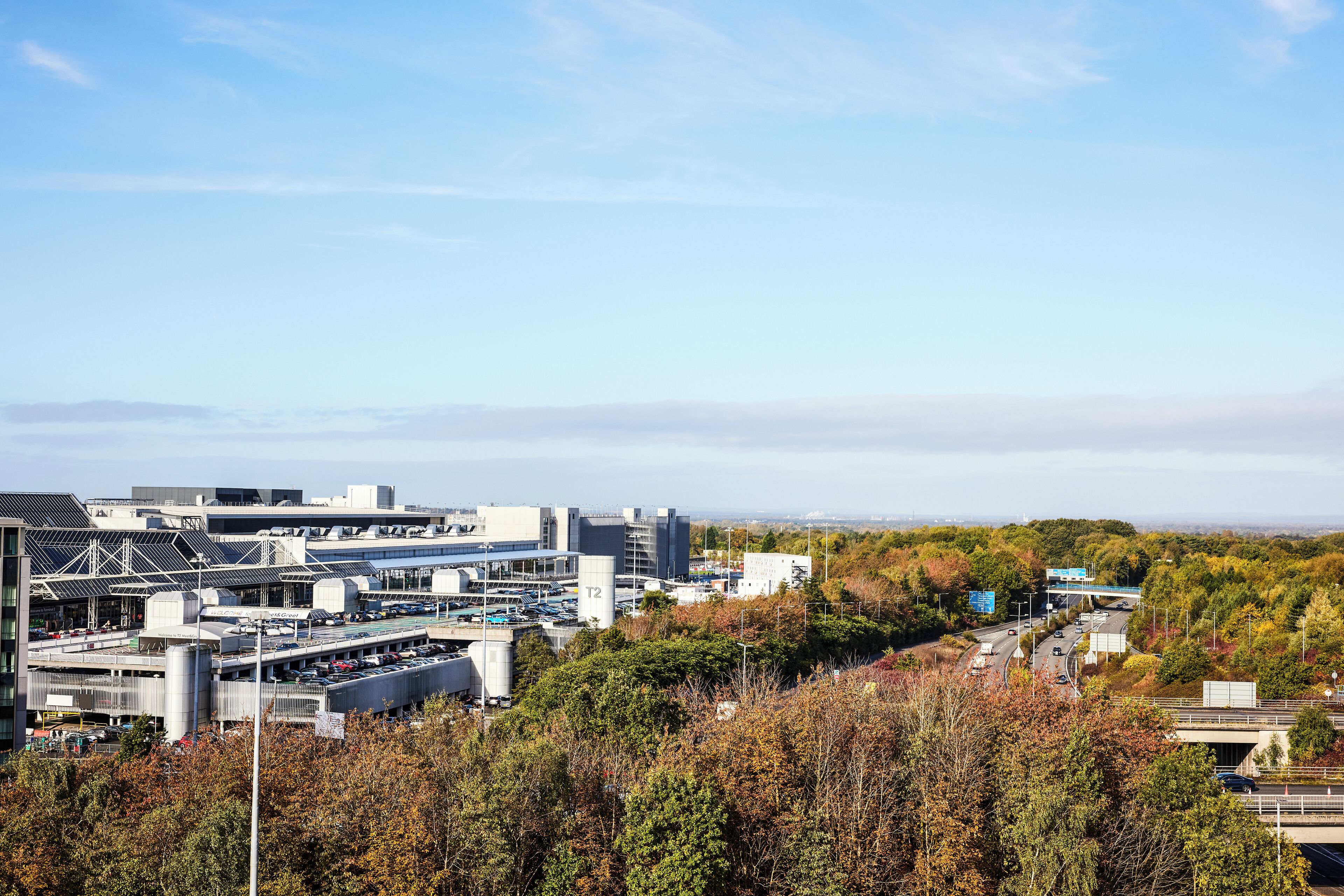 A modern building with multiple parking levels and a highway in the background.