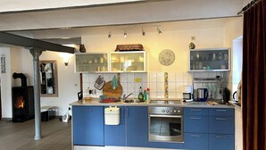 Una cocina moderna con gabinetes azules, horno empotrado y estufa.