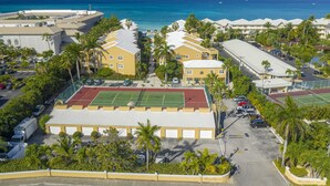 Een hotel met meerdere gebouwen, een tennisbaan en een parkeerplaats.