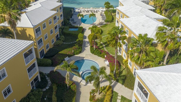 Een resort met meerdere gebouwen, een centraal gelegen zwembad en uitzicht op de oceaan.