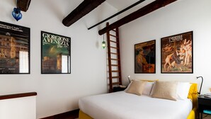 A bedroom with a bed, wooden beams, a ladder, and framed posters on the wall. - Tintoretto Cozy Duplex R&R (Venecia)