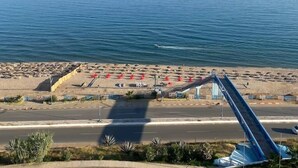 A beach with a blue slide, a road, and a clear sky. - Royal Tulip Skikda (Filfila)