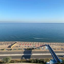 Praia particular, areia branca, espreguiçadeiras, guarda-sóis