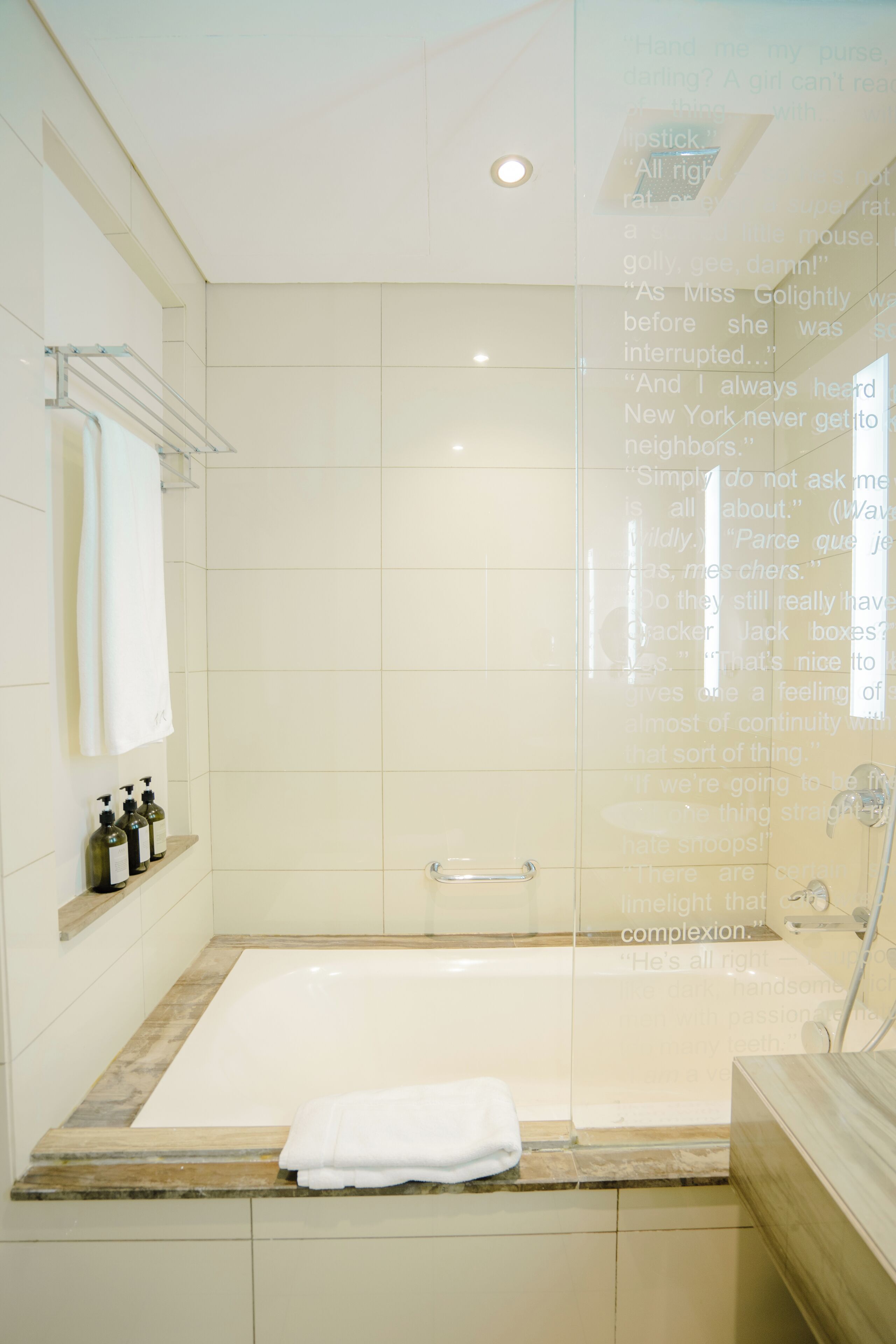 A modern bathroom with a bathtub, a glass shower enclosure, and a vanity with toiletries.