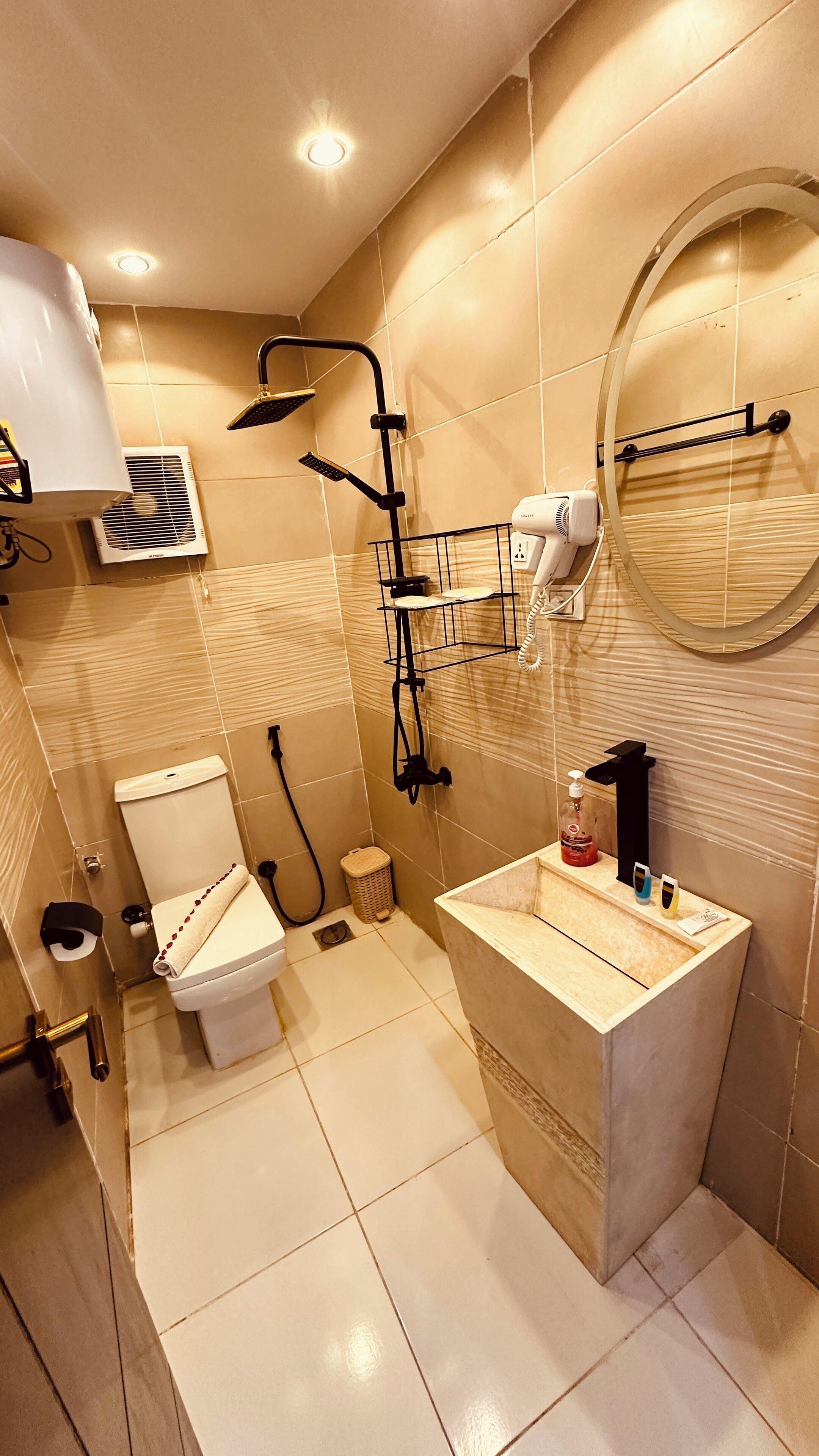 A modern bathroom with a toilet, sink, shower, and a mirror.