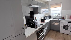 A modern kitchen with a built-in oven, microwave, and dishwasher. - Penthouse at the Bay near Edinburgh (Dalgety Bay)
