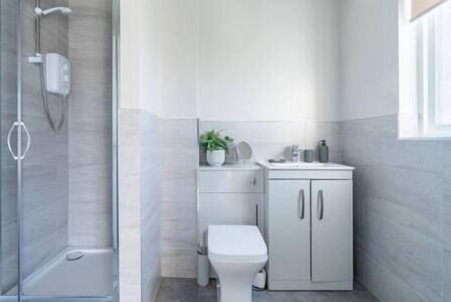 Un bagno moderno con doccia, servizi igienici e mobiletto.