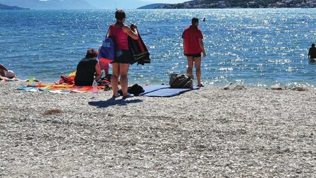 A pebbled beach with people sunbathing and swimming. - Modern Apartment Domina, With Balcony and Parking (Trogir)