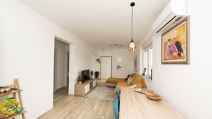 A modern living room with a sofa, a dining table, and a TV. - Modern Apartment Domina, With Balcony and Parking (Trogir)