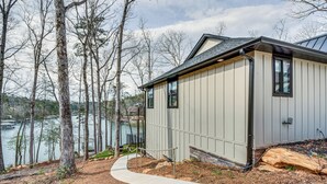 A house with a pathway leading to a dock, surrounded by trees and a body of water. - Lakefront Seneca Vacation Rental w/ Shared Dock! (Seneca)