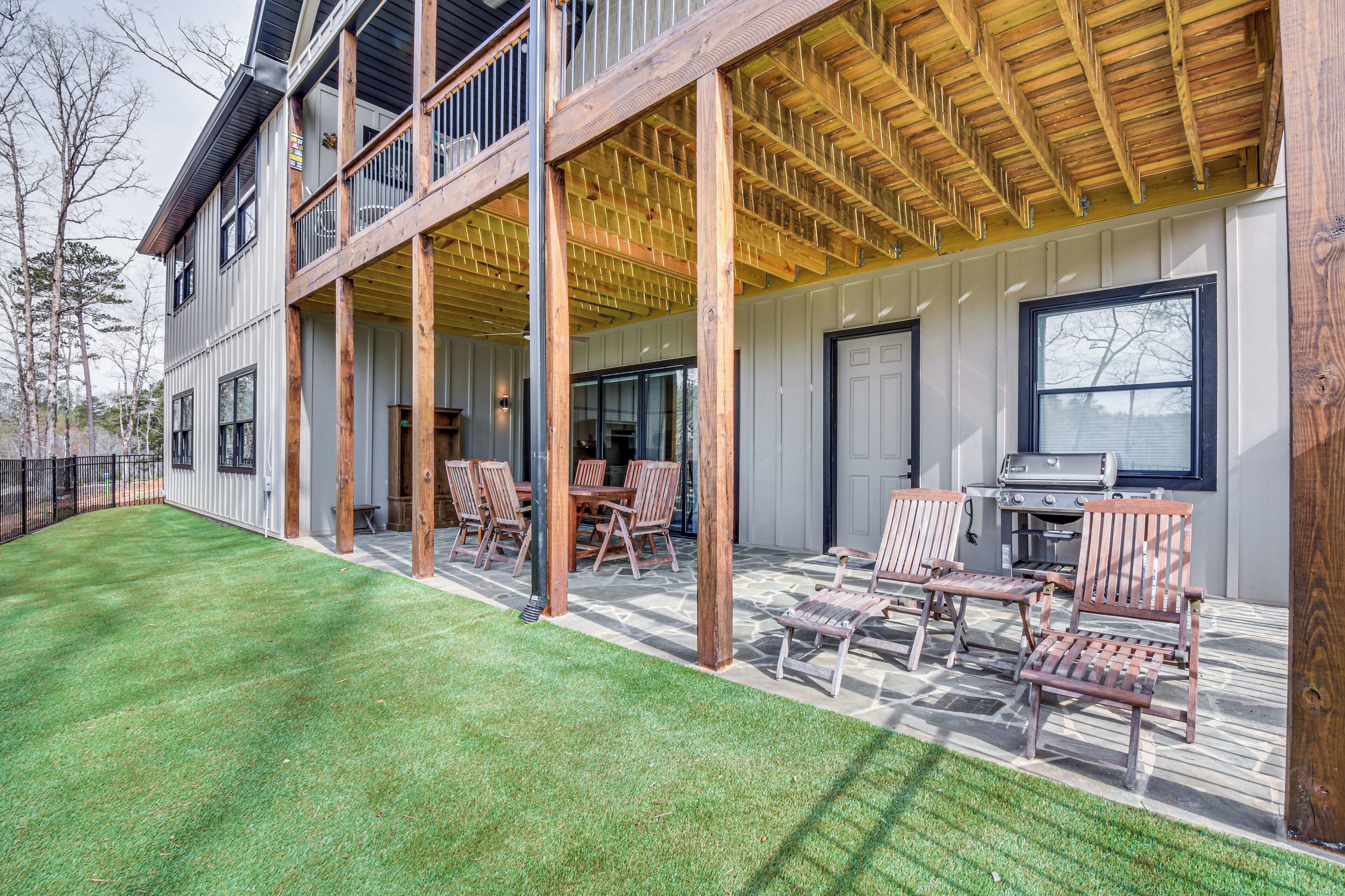 A two-story building with a covered patio area, outdoor seating, and a barbecue grill.