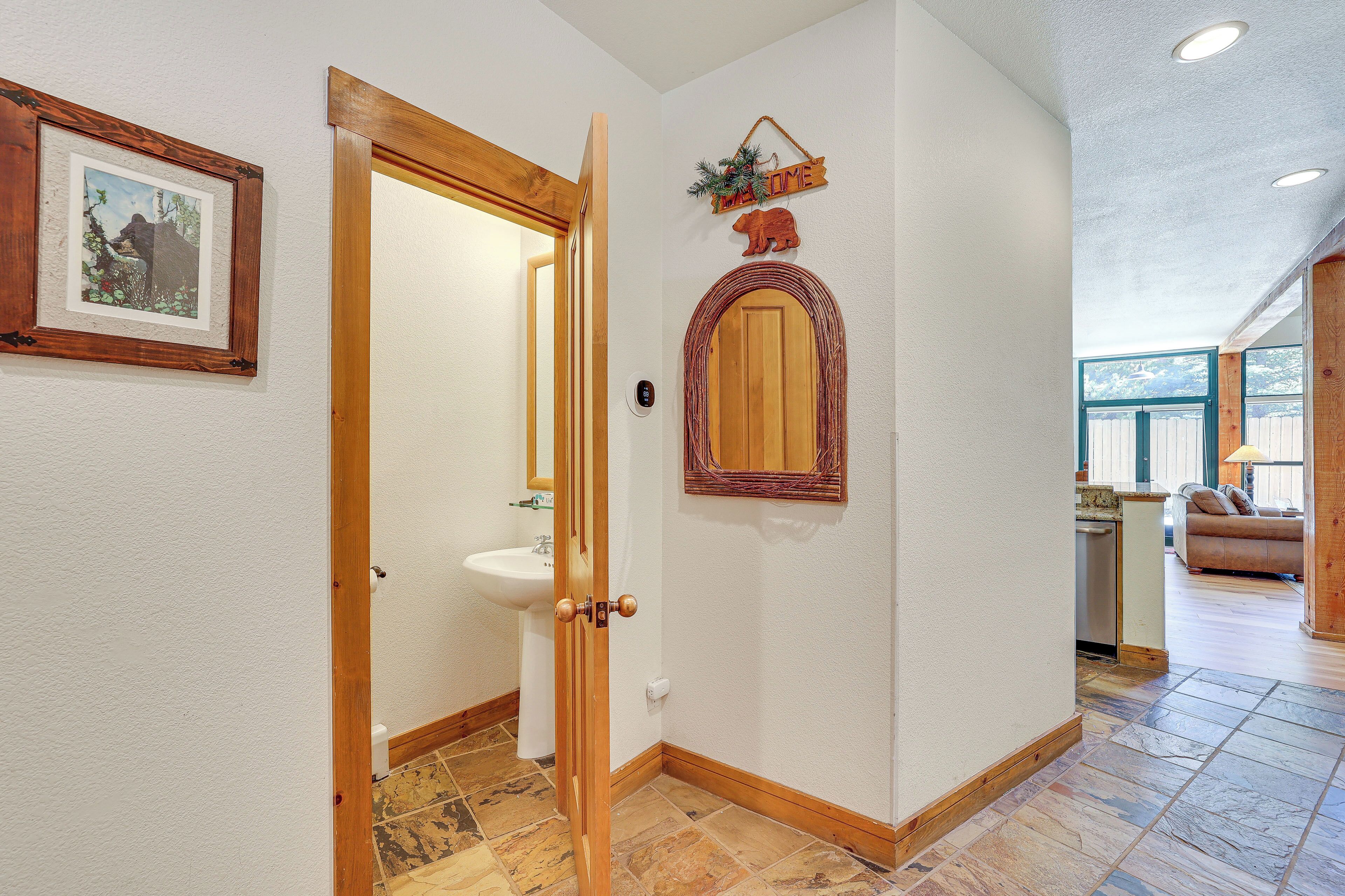 Un couloir avec une porte en bois, un tableau encadré, un miroir et une enseigne indiquant « DURÉE DE VIE ».