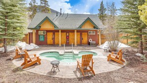 A lodge with a pool, wooden chairs, and a covered patio area.