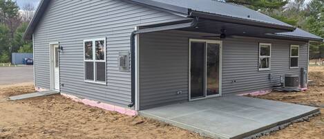 A single-story house with a covered garage, a concrete driveway, and a small porch.