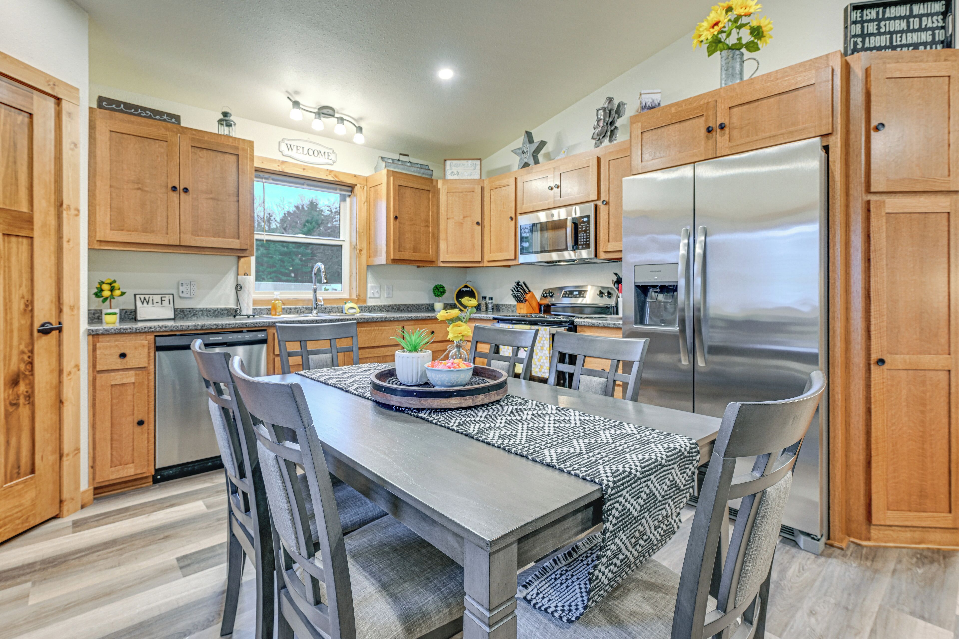 A modern kitchen with wooden cabinets, stainless steel appliances, and a central island with seating.