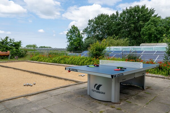 A billiards table with balls and cues, surrounded by greenery and solar panels. - Luxe Safaritent, Midden in de Natuur (Hensbroek)