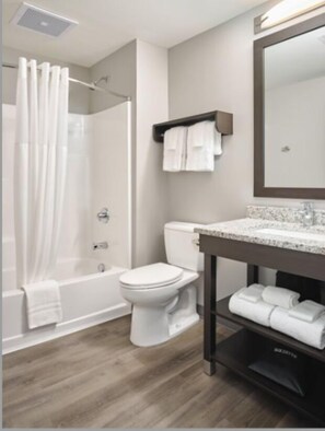 A modern bathroom with a shower, toilet, and vanity. - stayAPT Suites Madison-Greenbrier (Madison)