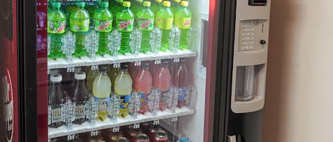 A Dr. Pepper vending machine with multiple beverage options including soda, juice, and energy drinks.