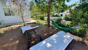 A wooden deck with a bench and a hammock.