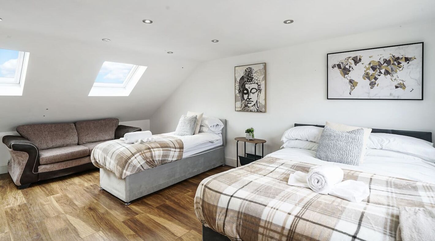 Un dormitorio moderno con techo estilo loft, un sofá, dos camas y una obra de arte con un mapa del mundo.