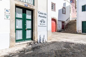 Un bâtiment avec une porte verte, une enseigne indiquant la réception et un escalier menant à une porte rouge.