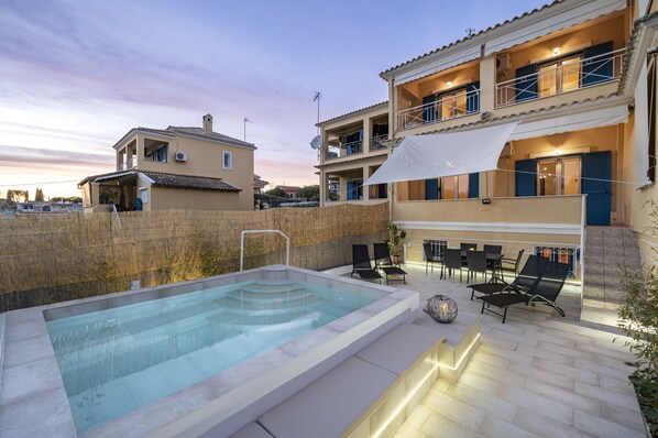A rooftop pool area with a glass enclosure, outdoor seating, and a two-story building with balconies. - Villa Nina with Private Plunge Pool by Konnect, 5 km to Corfu Town (Corfu)