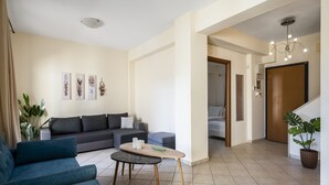 Un salon moderne avec un canapé, une table basse et un escalier menant à une autre pièce.