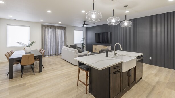 A modern kitchen with a central island, dark cabinetry, and pendant lighting. - Modern 3BR, Next to Pool, Hot Tub, Golf Views (St. George)