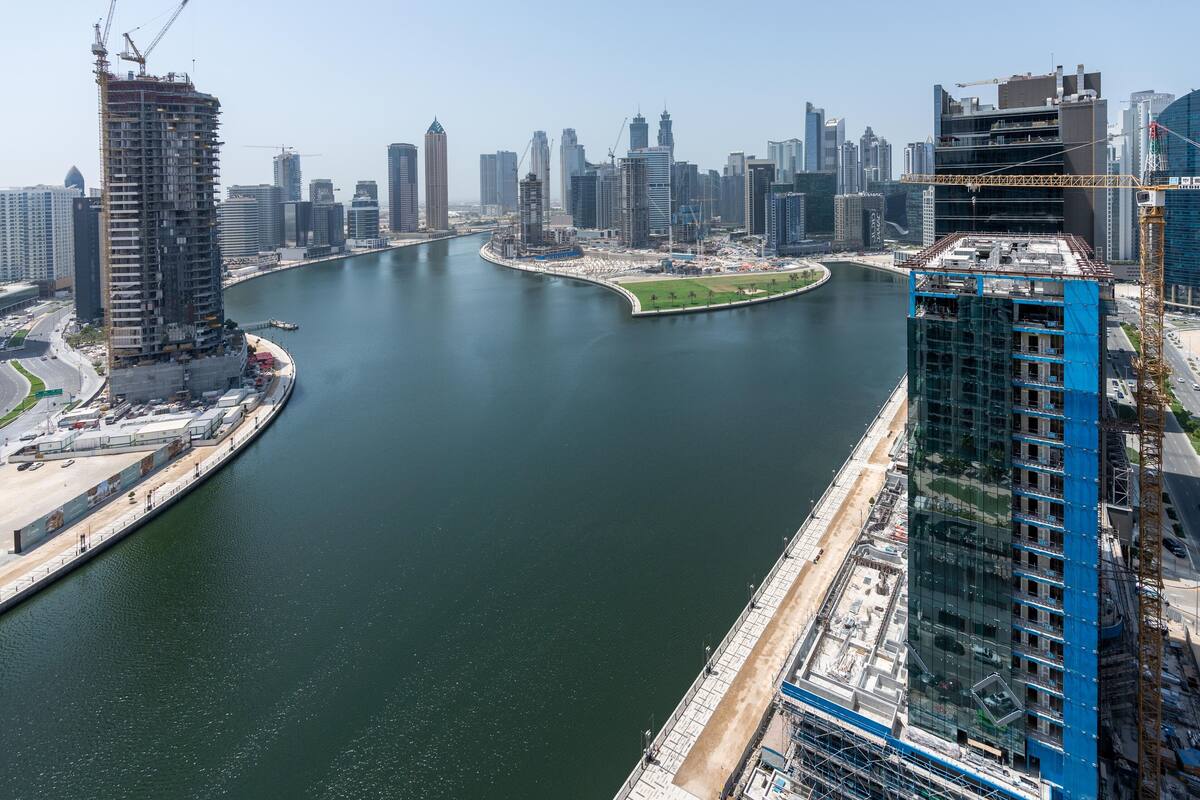 Ein Fluss mit einer gebogenen Brücke und einer Stadtansicht im Hintergrund.