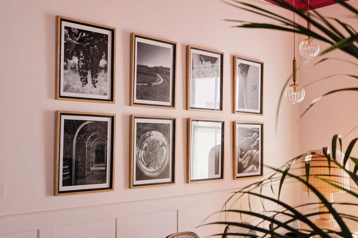 A wall with eight framed black and white photographs.