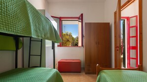A small room with two beds, a window, a wooden door, and a red bench. - 3839 La Dolce Casa by Barbarhouse (Melendugno)