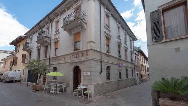 A building with a sign reading "CINEMATOGRA SPLENDOR" and outdoor seating with tables and chairs. - Residence Orti 18 by Wonderful Italy (Salò)