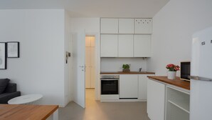 A modern kitchen with white cabinets, a wooden countertop, and a built-in oven. - Residence Orti 18 by Wonderful Italy (Salò)