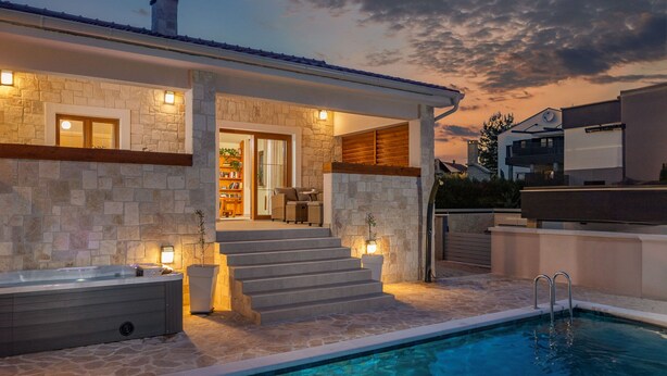 A modern house with a stone exterior, a pool, and a covered patio area. - Villa Alora Zadarvillas (Novigrad)