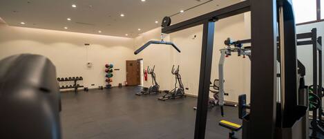 A gym with exercise equipment, weight racks, and treadmills.