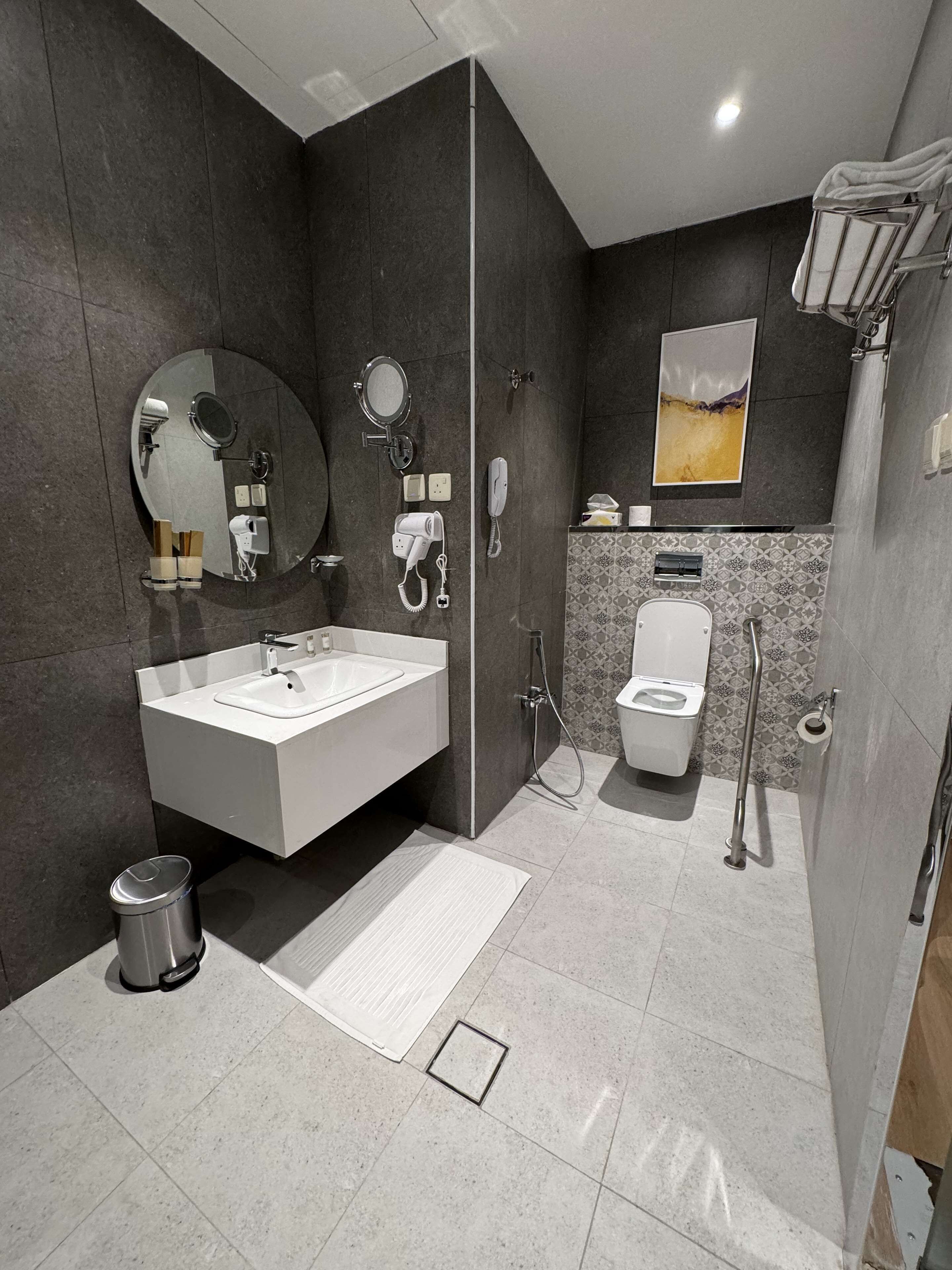 Une salle de bain moderne avec un grand lavabo, un miroir et des toilettes.