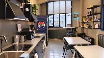 A modern kitchen with stainless steel appliances, a large window, and a Pepsi logo.
