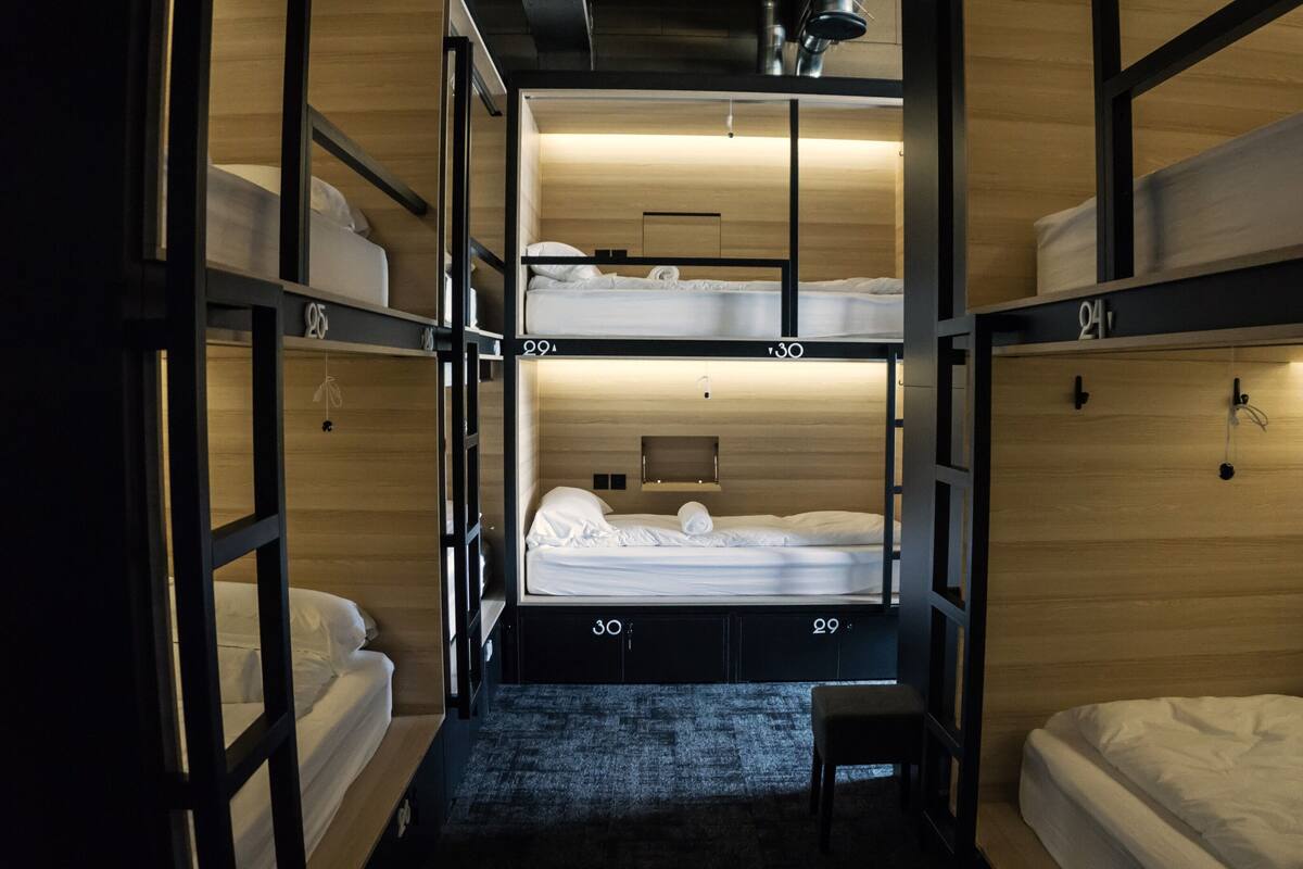 A bunk bed room with a central bed and two smaller beds on either side.