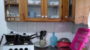 A kitchen with wooden cabinets, a gas stove, a sink, and a countertop. - Horse Shoe Villas A family friendly 2 bedroom villa near to it all  (Port Antonio)